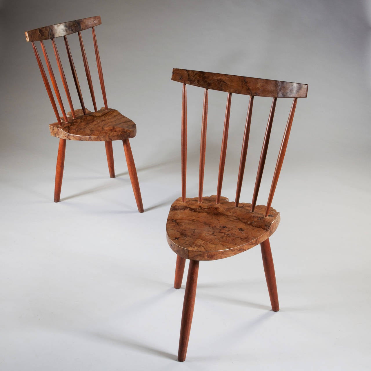 A pair of mid 20th century side chairs, with spindel back and burr walnut seats and back rests. 

After George Nakashima (1905-1990)