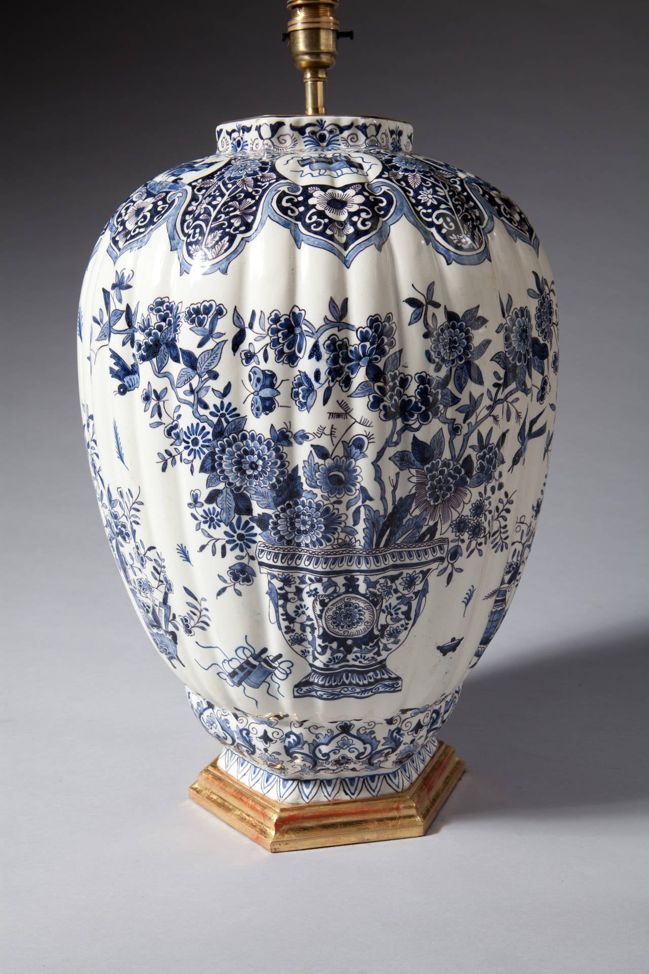 A pair of late 19th century Delft vases of large scale, decorated with an urn and sprays of flowers.