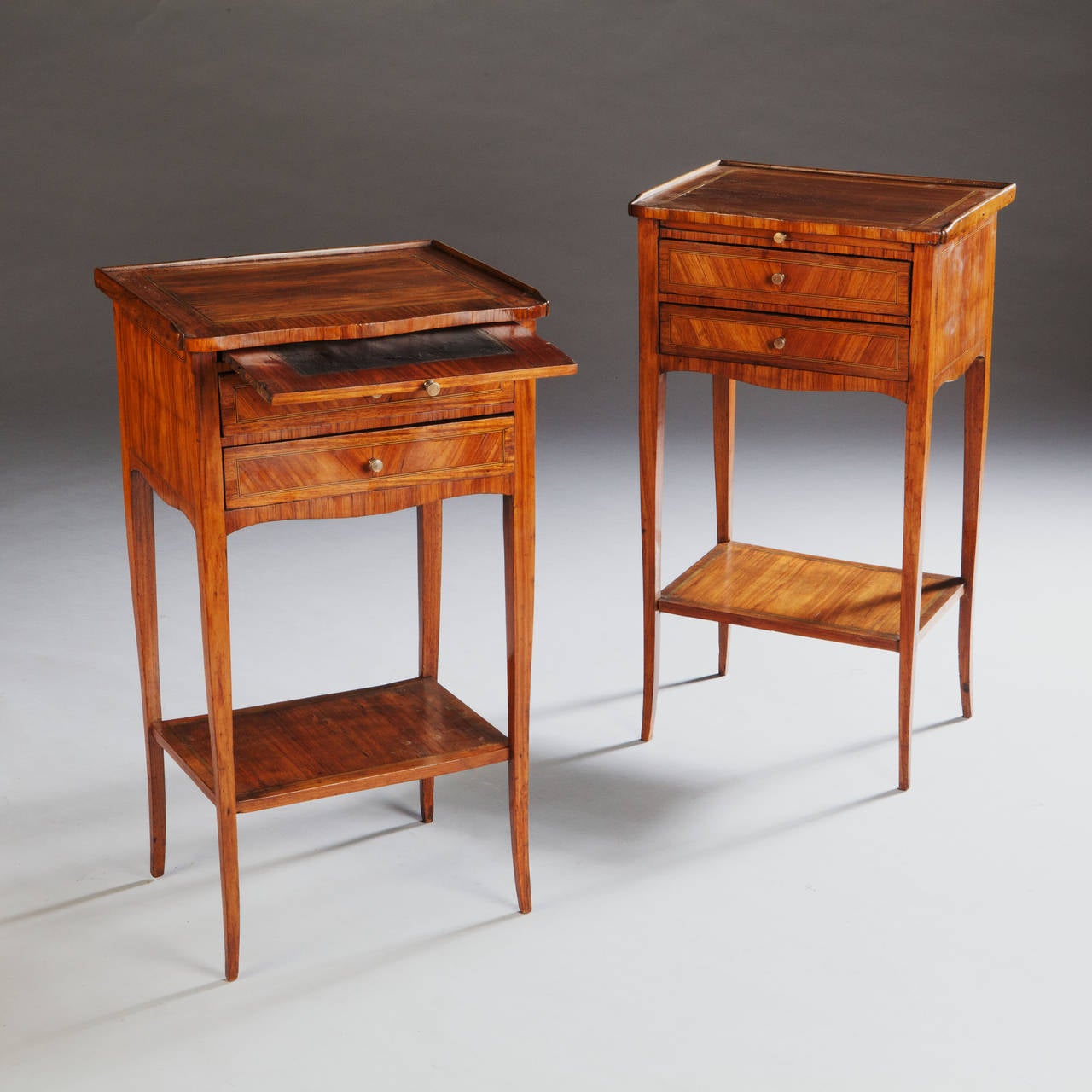 A fine pair of mid nineteenth century tulip wood veneered bedside tables with two drawers and reading slide, all supported on tapering legs.