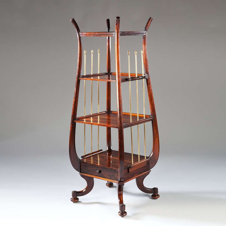 A rare and unusual 19th century Regency period Lyre Sided Whatnot Etagere, the shaped sides supporting three tiers above a sub structure with a drawer, the sides with brass flutes with finials, the whole raised on incurved legs terminating in