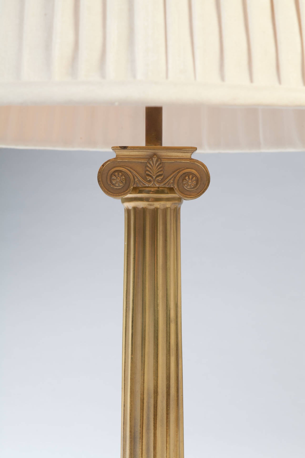 A fine pair of early twentieth century brass fluted column lamps with Ionic capitals