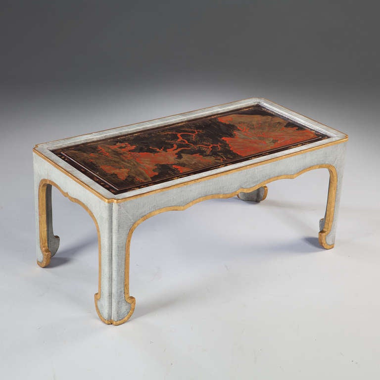 A fine and unusually small scale low table with a craquelle paint finish in light blue, the black 19th century Chinese export lacquer panel with red and gilt figures within mountains. 

By Mallett of New Bond Street