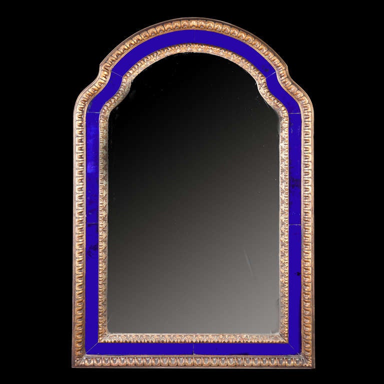 A vibrant blue bordered mirror frame with carved frame and hand blown glass panels. The upper section with a stepped frame.