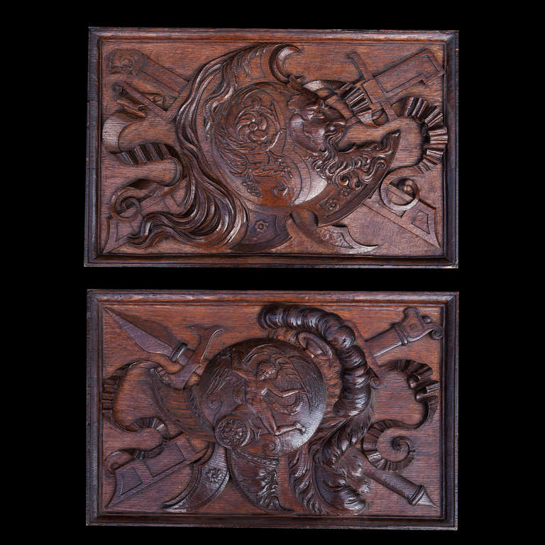 A fine pair of mid-19th century oak panels carved with trophies and masks.