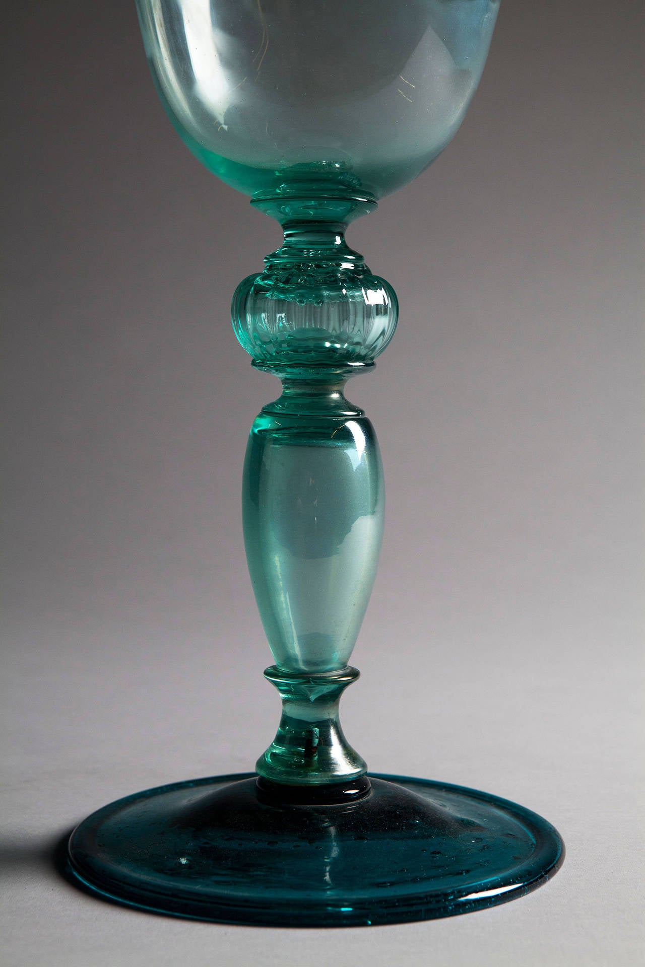 An unusual green Venetian goblet of large scale with a turned glass foot