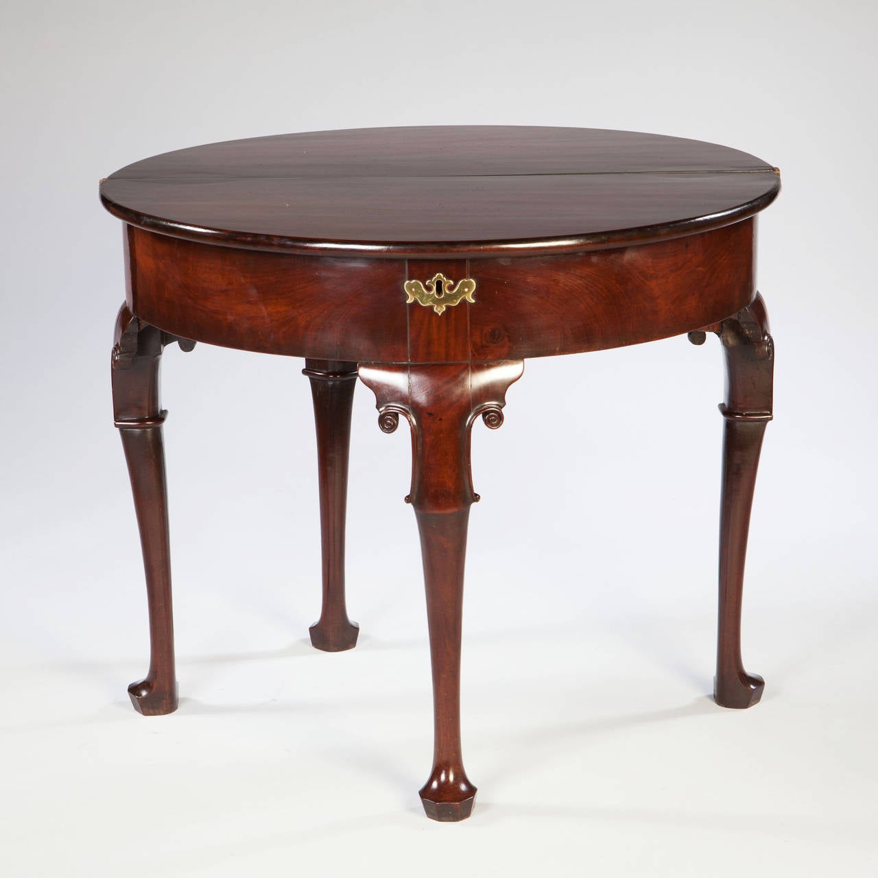 A rare mid eighteenth century mahogany tea table with central leg with stylised scrolls and hexagonal shaped foot, the top with finely figured mahogany, all supported on three tapering legs