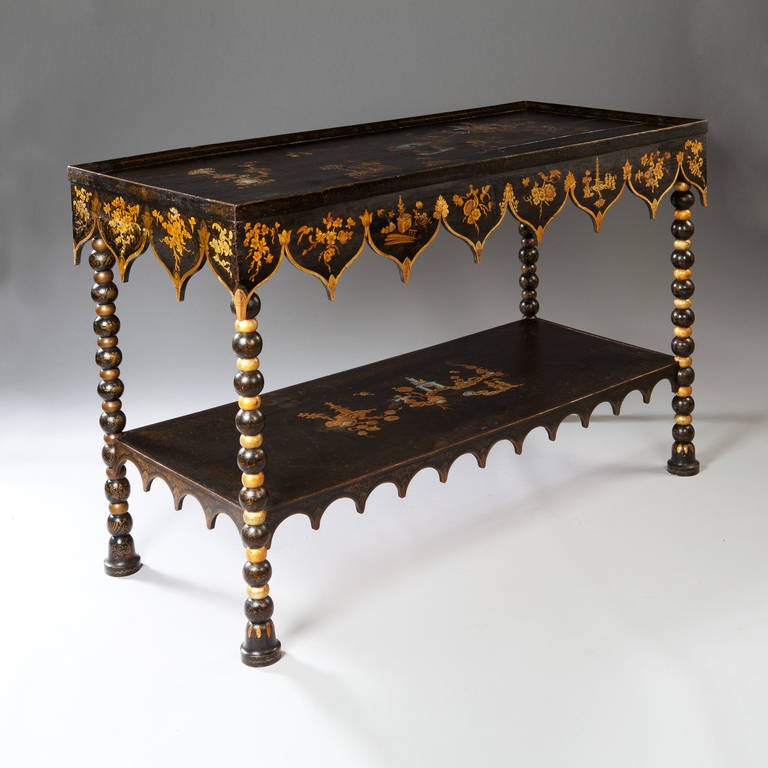 A very unusual and large scale 19th century black lacquer and gilt two tier side table, the two levels decorated with chinoiserie scenes detailed with mother of pearl and gold, the apron with its fabric inspired border is decorated with further gilt