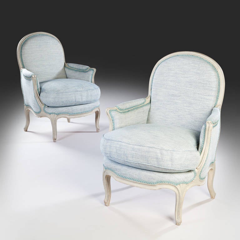 A fine pair of 19th century blue painted bergeres armchairs with generous seats and open arms. 

After a design by Jean Baptist Tilliard, circa 1760. The design shares the curved top rail and flat back, the outswept arms and the fan ornament on