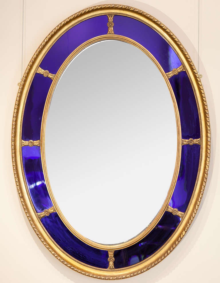 A fine 19th century giltwood oval mirror with blue glass borders.