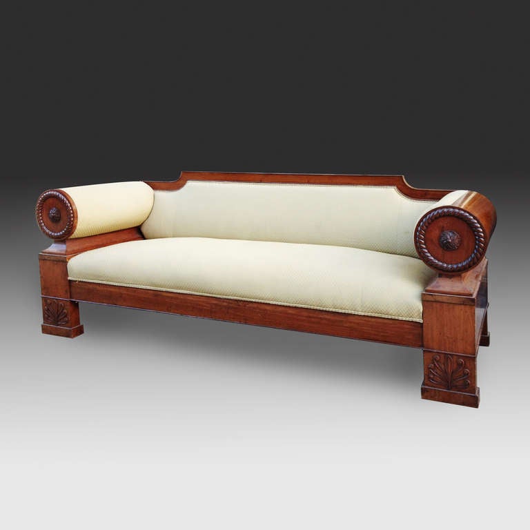 A fine early 19th century mahogany overscale sofa, with circular arm supports surrounded by rope twist deocortion around a central paterae, each raised on legs with bold carved anthemions.