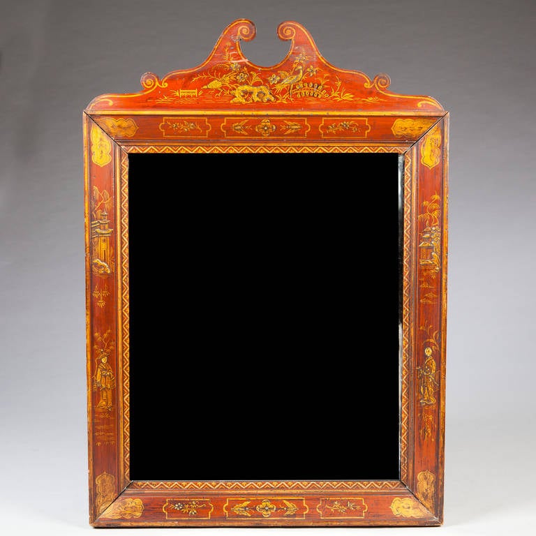 A fine late 18th century red japanned mirror with scroll pediment and decorated borders.