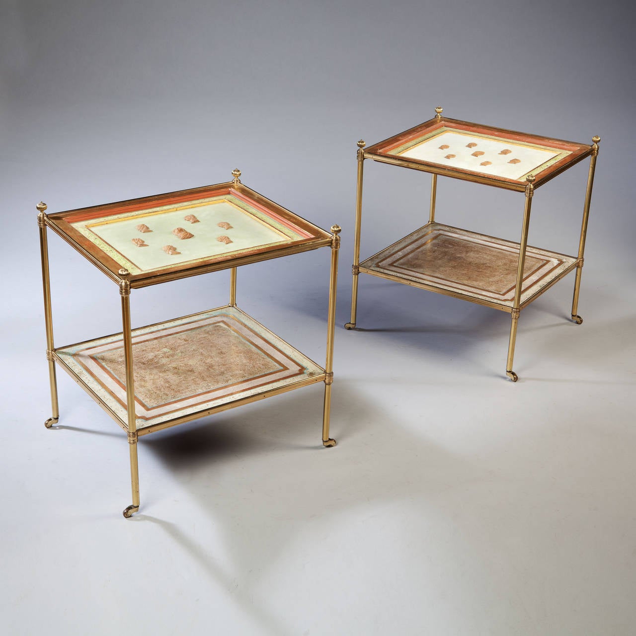 A fine pair of mid 20th century two tier brass tables with gilded and craquelle borders inset with miniature portrait reliefs.
