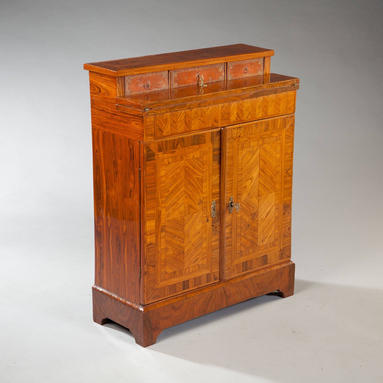 A fine 19th century Louis XIV rosewood bureau cabinet of unusually small proportions. The stepped upper section opening to a sliding writing surface with two sunken drawers and three leather fronted boxes. The lower section with cupboard doors