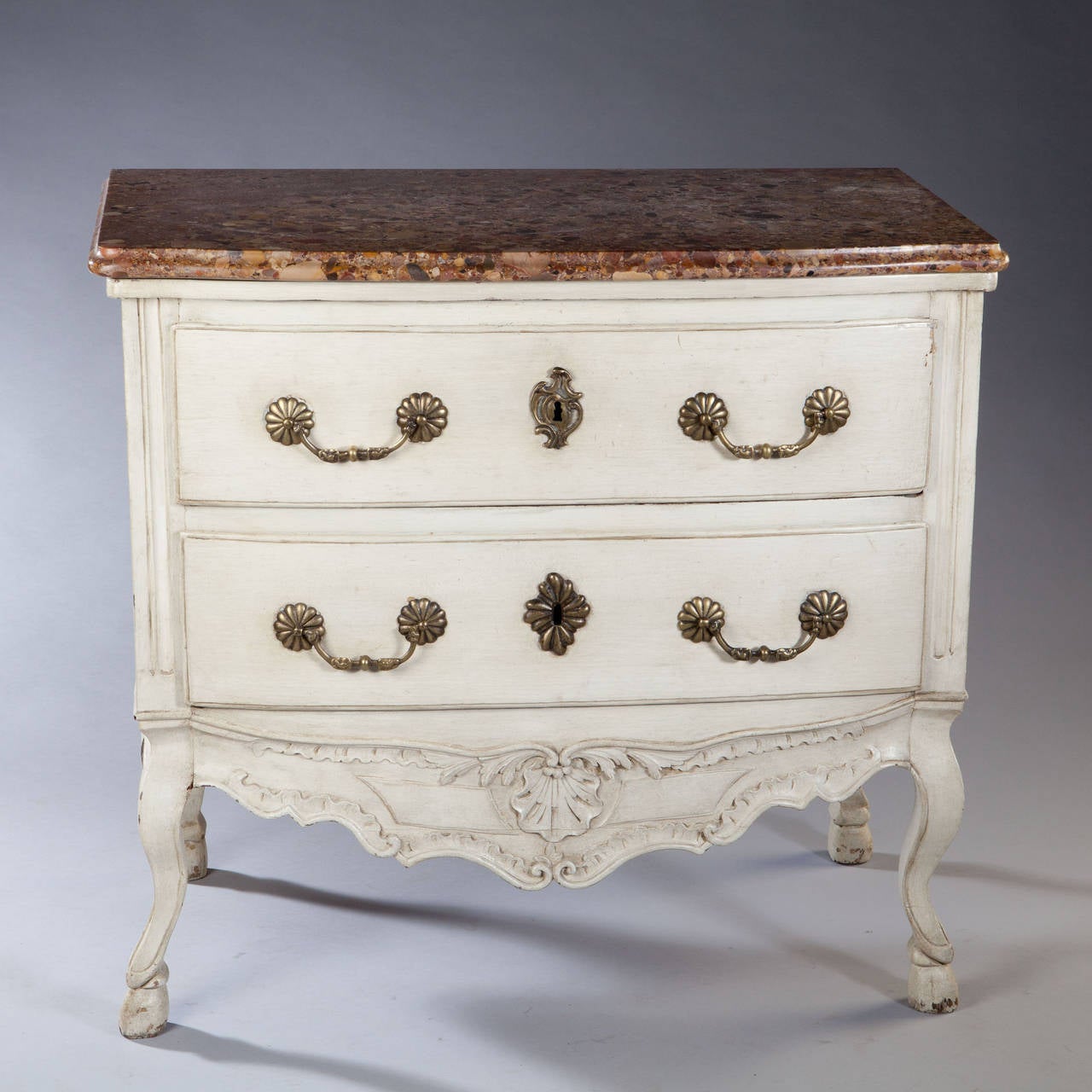 A fine early 18th century French Commode with breche d'alep marble top above two long drawers supported on cabriol legs, the front with a carved apron and central shell motif. The sides also decorated with recessed moldings and sweeping apron. The