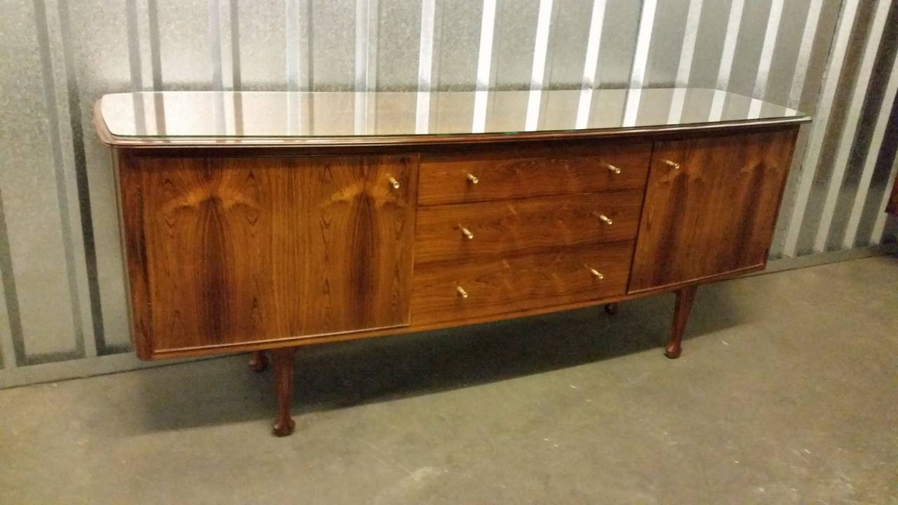 A rare and fine Indian rosewood sideboard credenza by the award winning designer Andrew J Milne, designed circa 1955 for Heals of London.
Exceptional quality and style as always with this top designer.
Each end of this sideboard is curved front