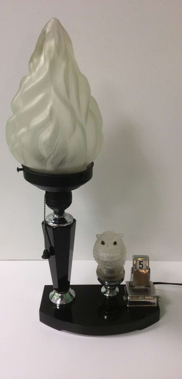 A really superb Art Deco Table Lamp with illuminating Owl and Calender, the lamp is on a black glass base with faceted black glass column, original glass torcher shade, the Owl figure is also glass, pull switch for on off and owl lite.
