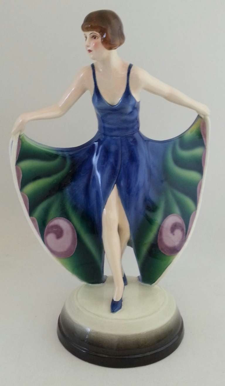 Goldscheider (1885-1938) 
Art deco figure a model by Josef Lorenzl (1892-1950) 
An impressive Art Deco polychrome porcelain figure with butterfly wing dress. 
This model in a blue and green color with purple decoration 
Model number 55715 
39