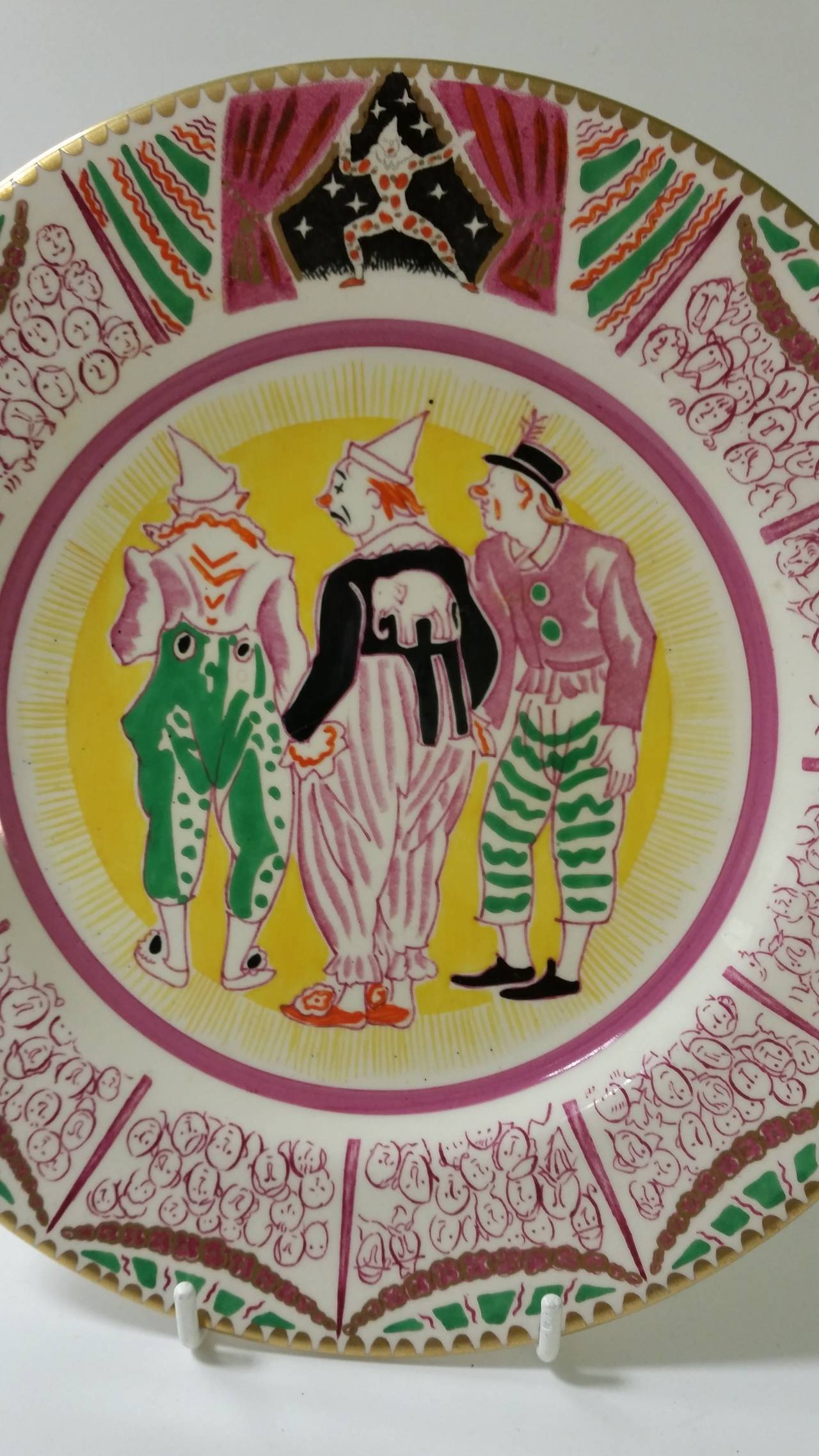 Laura Knight Circus design Plate produced in Bizarre By Clarice Cliff. 
These designs were produced for the 1925 Harrods Exhibition. 
Signed Laura Knight and Clarice Cliff. 
First Edition 1934. 
9 inch Dia
Laura Knight, circus themed plate,