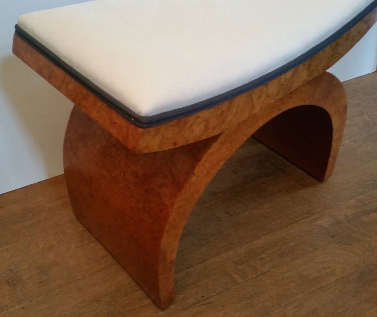 Art Deco stool in a beautiful bird's-eye maple with curved top and base, re-upholstered in a cream Alcantara with black pipping. 
Harry and Lou Epstein. Renowned Art Deco furniture producers. 
Measures: 46 cm H, 54 cm W, 32 cm D. 
British, circa