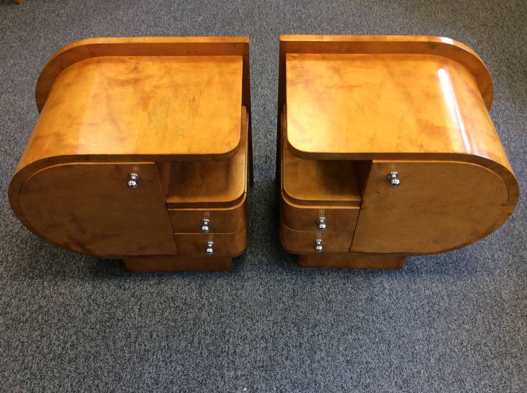 A great pair of Art Deco satin maple bedside cabinets, very stylized shape. 
54 cm H, 59 cm wide at the back 40 cm deep including handles.