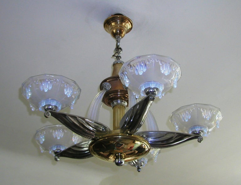 An exceptional Art Deco bronze and nickel-plate five branch chandelier by Petitot, opal glass shades and waterfalls.
Measure: Overall diameter of approximately 85cm with a minimum drop of approximately 75cm, this can be increased with extra chain