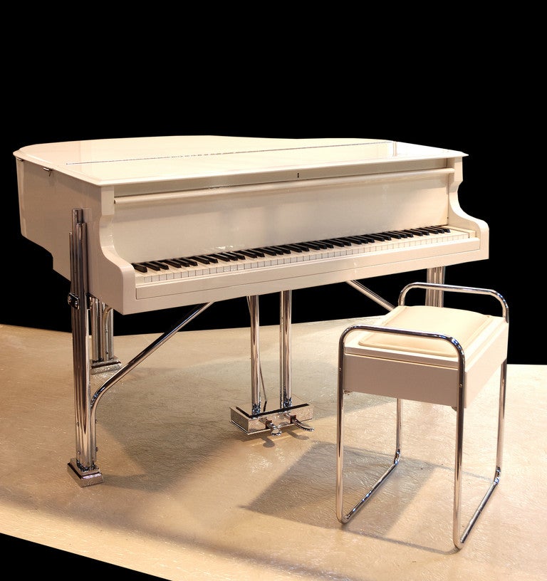 A Rare Example of the Highest Quality Art Deco Ivory Lacquered Carl Ebel Baby Grand Piano with a Matching Piano Stool Raised upon Impressive Tubular Chrome Legs with Floating Pedals. Re-chromed and Re-finished in an Ivory Lacquer.
C 1930 German.