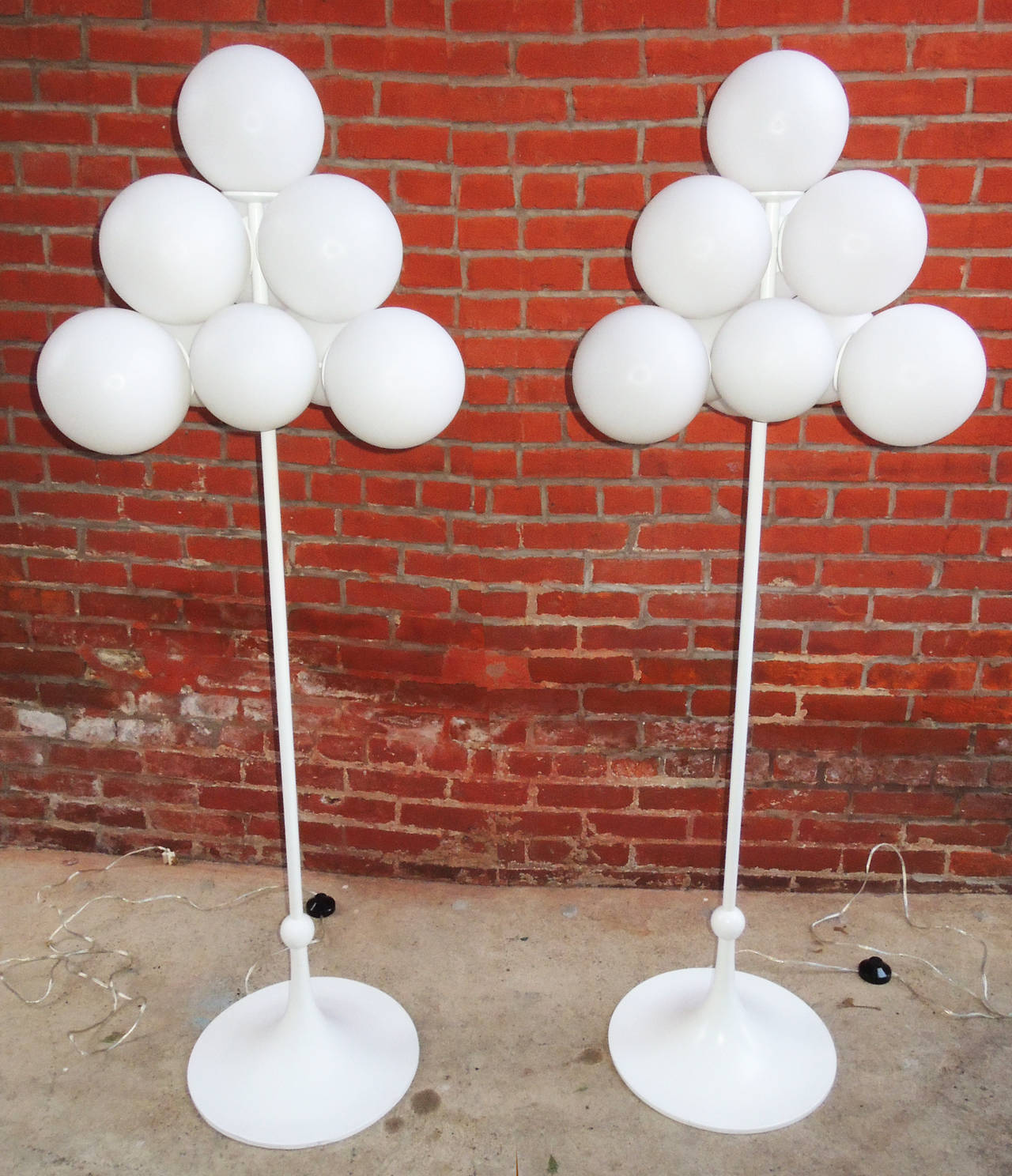 Pair of standing lamps by E.R. Nele. Ten separate white frosted glass globes screw in individually to cover bulbs. Attached to a white lacquered metal armature, with tulip shaped round foot.