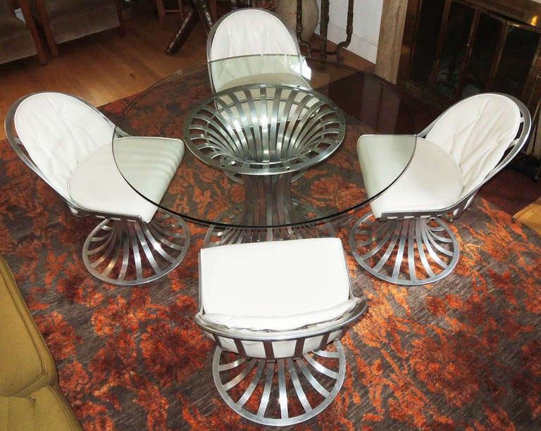 Table and 4 chairs made of extruded aluminum by Lee L. Woodward & Sons of Owosso, Michigan circa 1960. Chairs swivel and are hand riveted. Good quality synthetic leather is original, and stuffing in good shape. Glass top is 1/2 inch thick with a