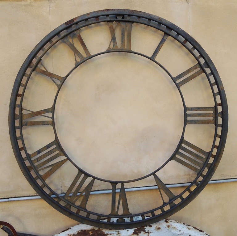 Very large cast iron clock face. European -- French or English. Strong roman numerals framed by a circle of radiating points marking the hour with a triangle, the quarter hours 
with straight marks. The design of the numerals is the same as used by