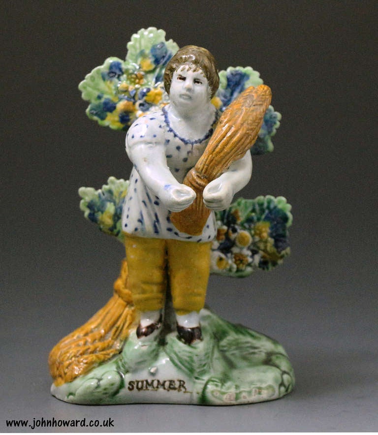 Antique Staffordshire pottery early bocage figure titled Summer. 
The figure is decoarted in underglaze colours in the Prattware palette. 
The modelling of the figure is naive but detailed in a very charming fashion.