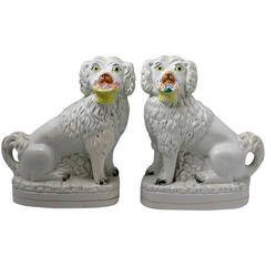 Staffordshire pottery dog figures with baskets of flowers mid 19th century