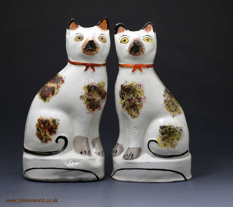 Antique Staffordshire pottery pair figures of seated cats Victorian period mid 19th century. The figures are naively modelled and decorated which only adds to the charm of this rather perky looking couple. Such figures are increasingly rare as are