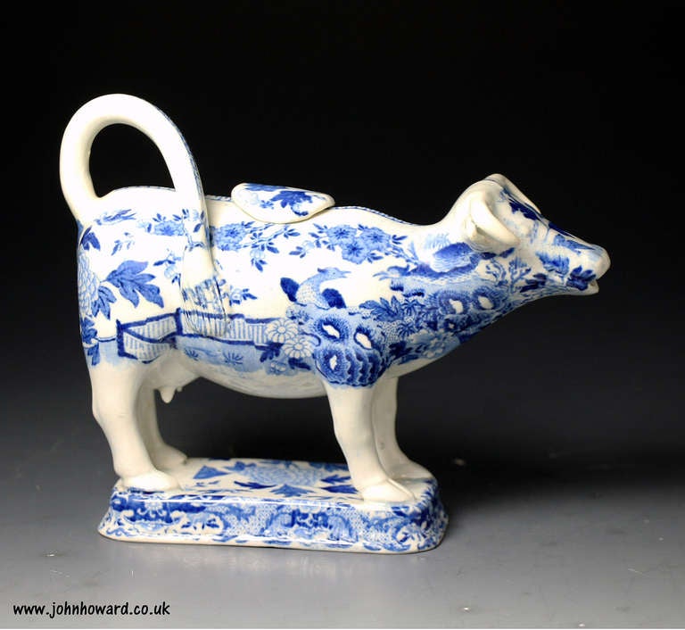 An unusual English pottery figure of a cow in the form of a creamer and decorated with an all over underglaze blue and white transfer print. Antique period circa 1820/30.
The figure is in very clean condition with only minor restoration at the