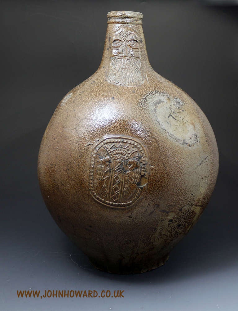 Antique Bartmann( Grey beard) Bellarmine tiger saltglaze earthenware bottle Rhineland Germany 17th century.
The bottle is decorated with a medallion and the face commonly thought to be Cardinal Bellarmine whose bearded face has been immortalized on