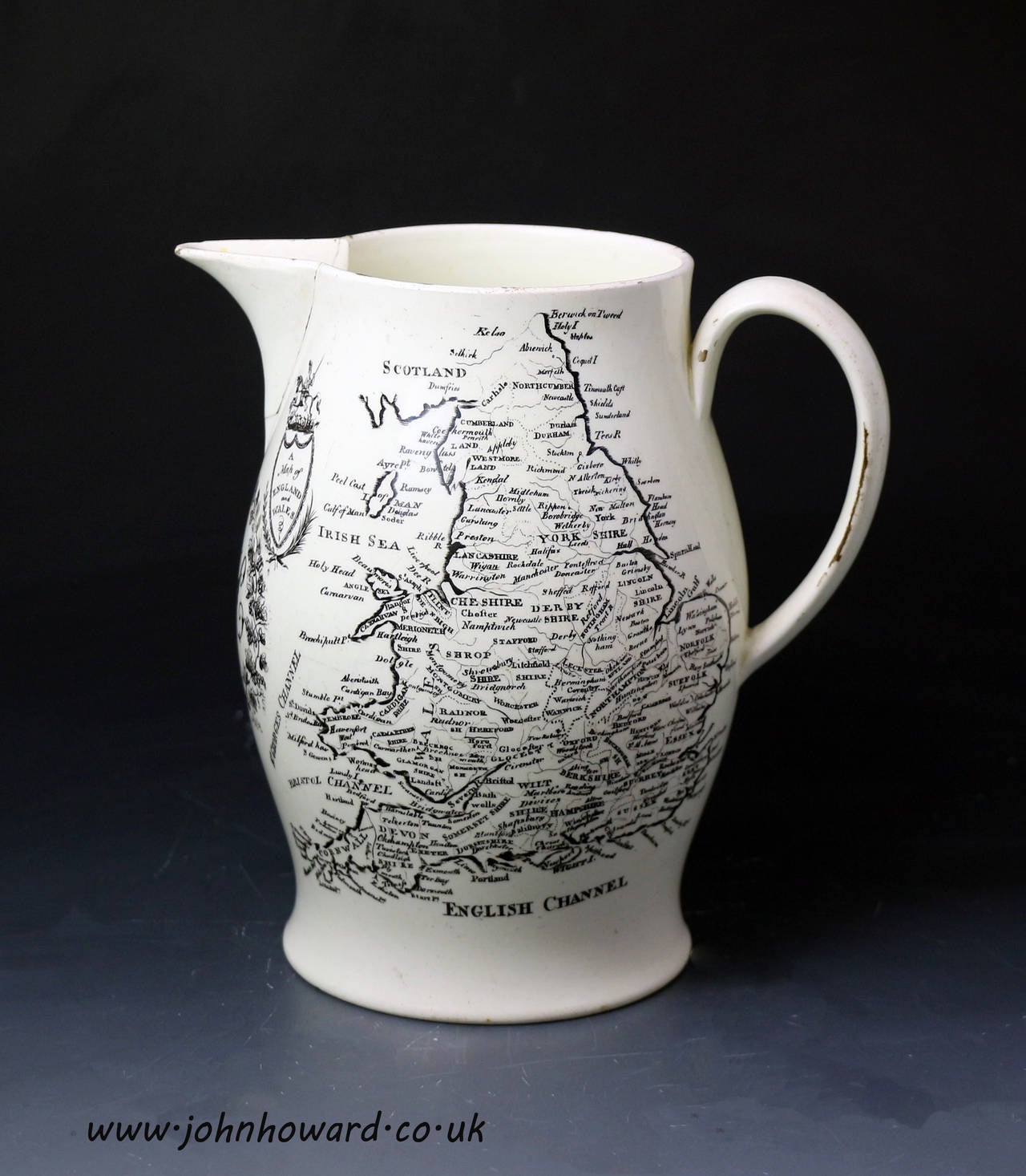 A rare antique English creamware pottery pitcher with underglaze transfer print of a detailed map of England and Wales. The reverse has a transfer print of a felamle figure with an anchor symbolizing 