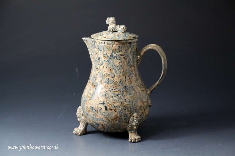 Antique Staffordshire pottery agate ware pitcher and cover.
The earthenware variegated clays are lead glazed on an earthware body.
The cover finial is a press moulded Chinese lion. The press moulded body of the pitcher is enhanced with three