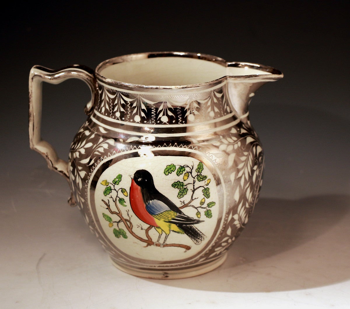 Antique silver luster pottery pitcher with image of a Robin. 