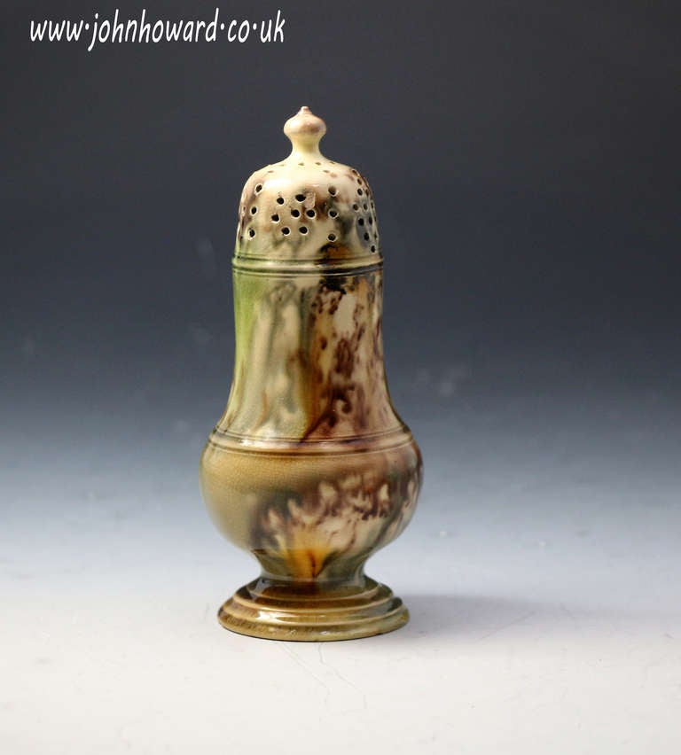 Antique English pottery shaker with a creamware body and typical lead glaze in the Whieldon manner.