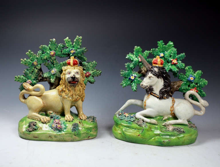 English Staffordshire pottery pearlware figures of the Lion and the Unicorn with bocage decoration.
The figures represent the Royal Coat of Arms of Great Britain.
These figures are marked with the famous scroll deice adopted by John Walton in his