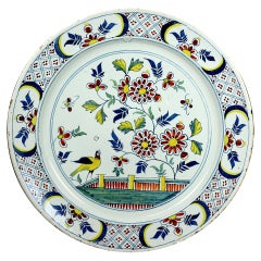 English delftware pottery charger in polychrome colours c1730 