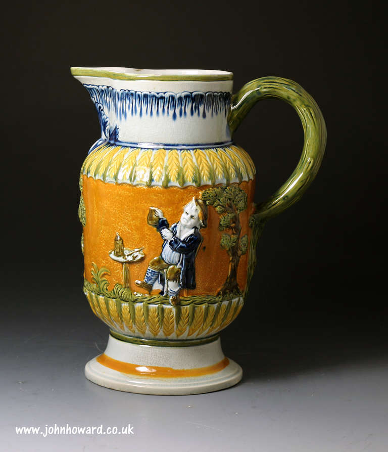 A fine example of an antique Prattware relief molded pitcher.
The pitcher is decorated with the Parson, clerk and sexton figures who are portayed smoking and drinking.

The pratt colouring is very strong and vibrant and the relief work is very