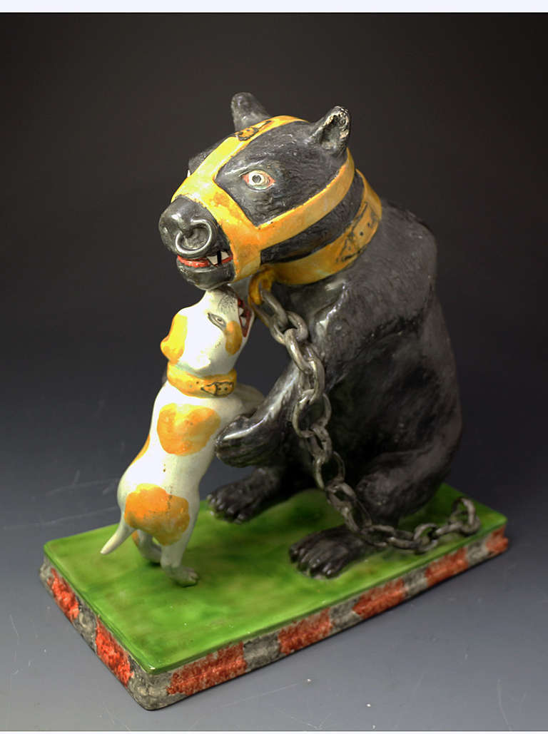 A rare antique period Staffordshire pottery pearlware figure of a chained bear baited by a bull terrier. The figures are modelled on an oblong base.
There is strong attention to detail on this piece which captures a point in our social history.