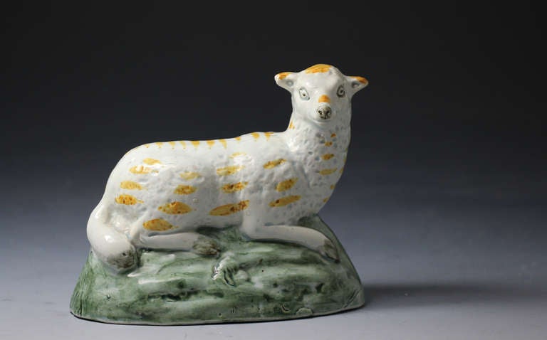 A good example of early creamware bodied English pottery. The recumbent ewe is modeled on a green base and would date to circa 1800. The color oxide decoration is underglaze and the figure is crisply molded will a warming characterful appeal.
The