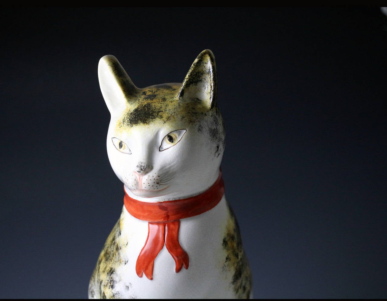 A rare large pottery figure of a seated cat onan ovale green base. 
The figure is wonderfully modelled , the coat sponged decorated and wearing abright red collar. 
A fine striking piece full of grace and charm.