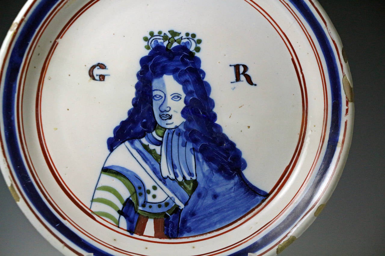 A rare polychrome decorated English pottery delftware plate with a half portrait of King George 1st. The fact that no numeric reference is given indicates that the image represents King George 1st and not the 2nd. The form of the plate and the
