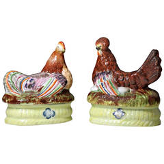 Antique Staffordshire pottery figures of hens on baskets with a flower motif