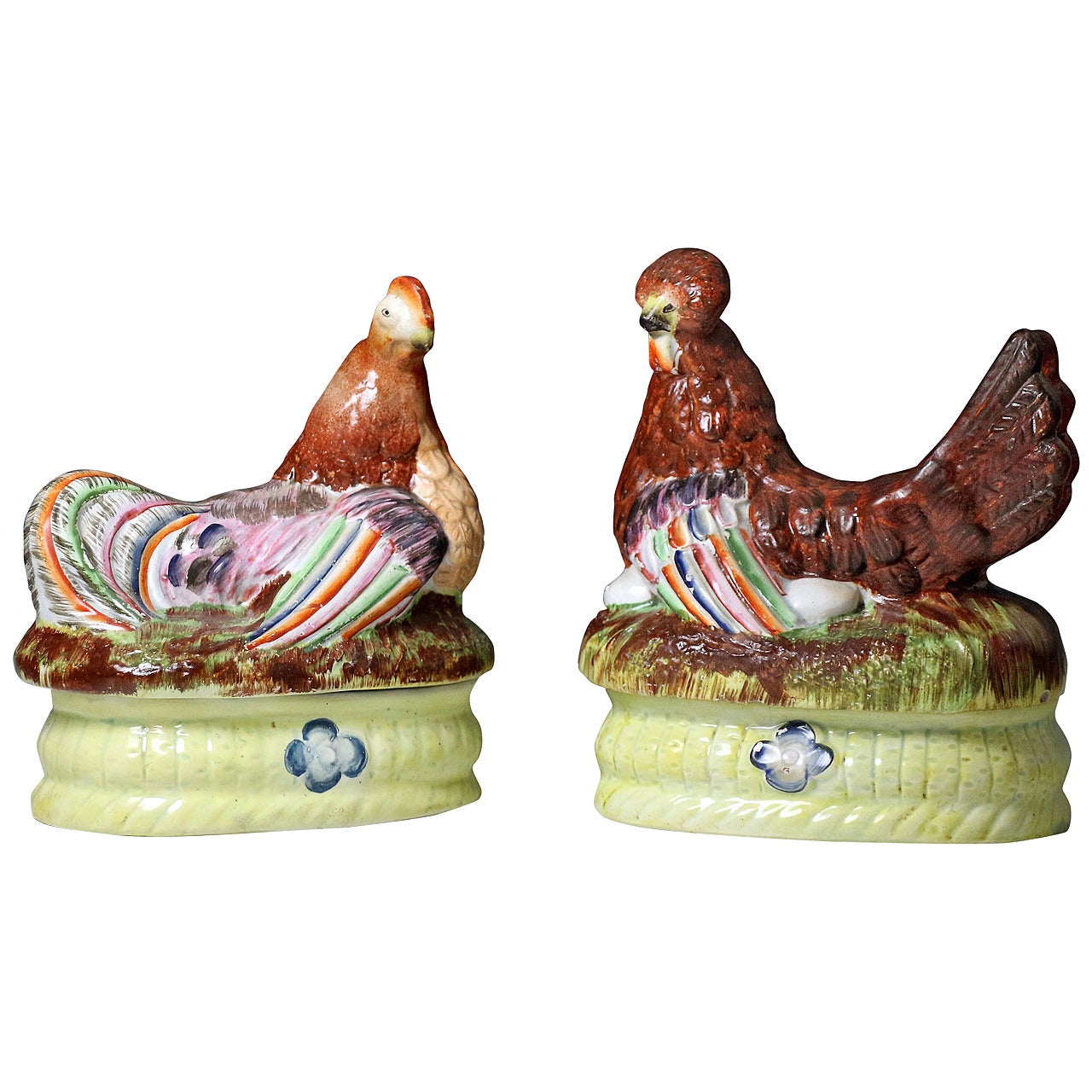 Staffordshire pottery figures of hens on baskets with a flower motif