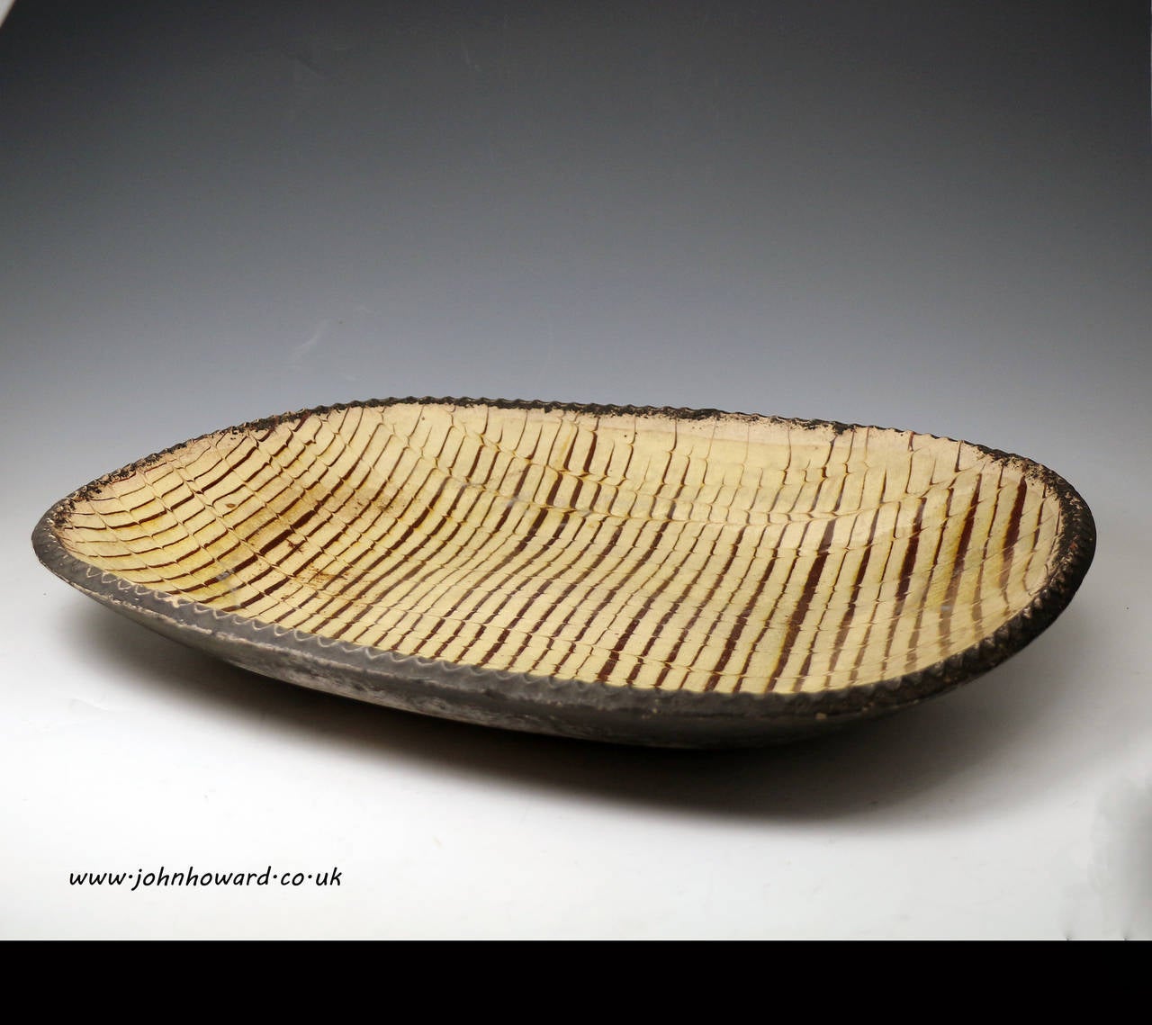 A good English earthenware slipware baking or loaf dish comb decorated. 
The underside of the dish is naturally and wonderfully patinated. 
Antique period late 18th century.