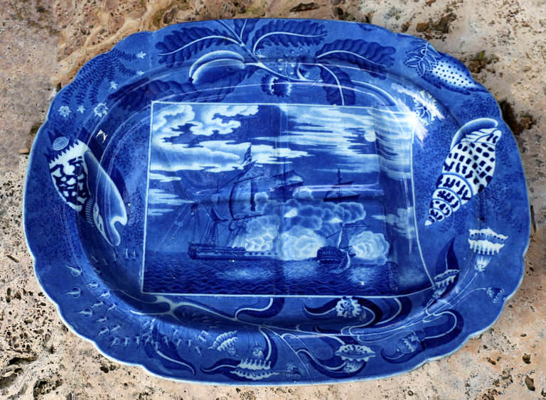 A fine Staffordshire pottery large size blue and white platter with a gravy well with an underglaze blue and white print of a Naval Night Battle. The border is decorated with shells continuing the sea theme. One of the best patterns produced by the