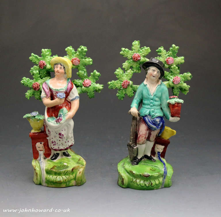 Antique Staffordshire pottery male and female gardeners with bocage. A bright decorative and appealing couple.